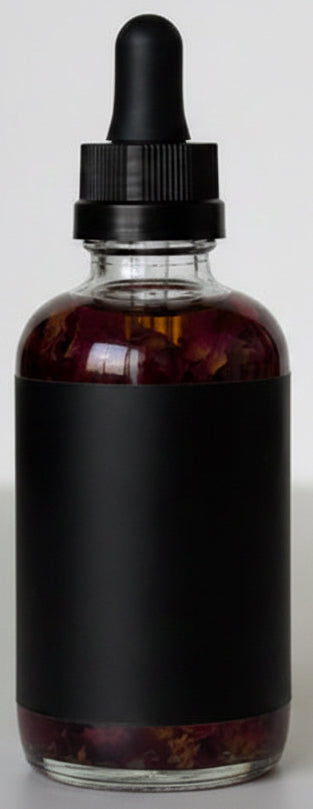Luxury clear glass bottle of hydrating body oil with real rose petals