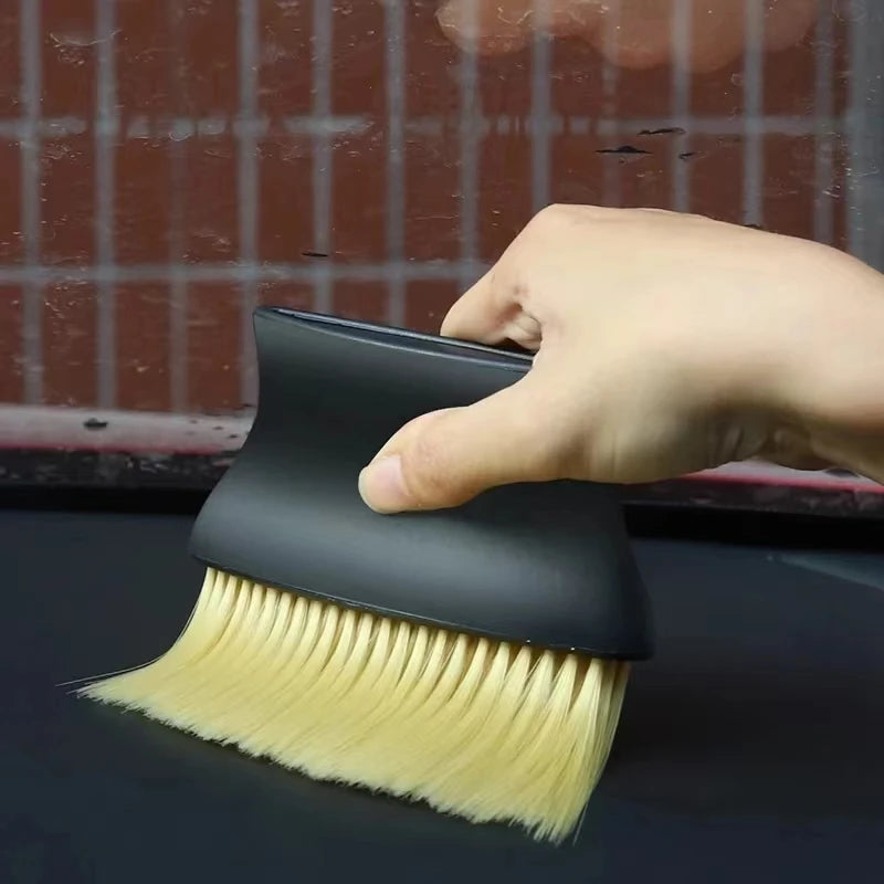 ergonomic car detailing brush removing dust from vehicle center console panels